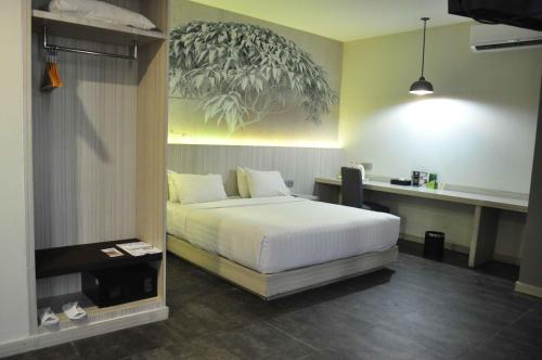 a bedroom with a bed and a desk in it at Grand Kolopaking Hotel in Kebumen