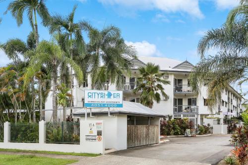 a building with palm trees in front of it at Citysider Cairns Holiday Apartments in Cairns