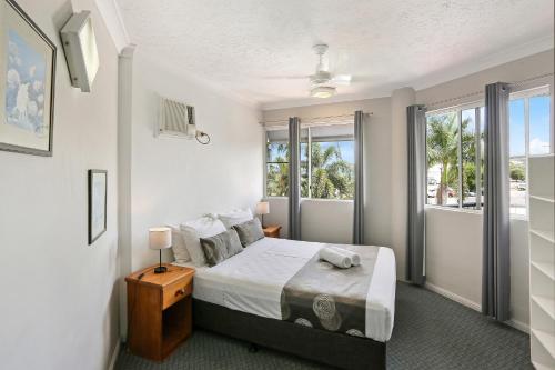a bedroom with a bed and a large window at Citysider Cairns Holiday Apartments in Cairns
