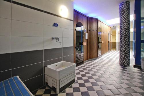La salle de bains est pourvue d'un urinoir et de carrelage. dans l'établissement Cottages in fir park, fir, à Tanne