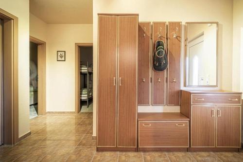 a locker room with wooden cabinets and a mirror at Cottage by the meadow, fir in Tanne