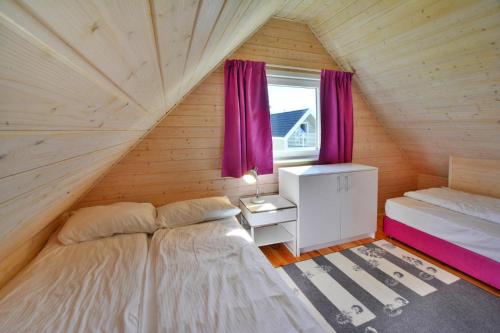 a bedroom with a bed and a window with purple curtains at Holiday resort, Sianozety in Sianozety