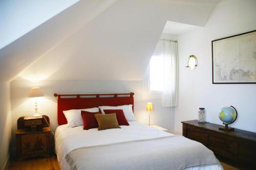 - une chambre avec un lit doté de draps blancs et d'oreillers rouges dans l'établissement Holiday Home near St Jean du Doigt Beach, à Plougasnou