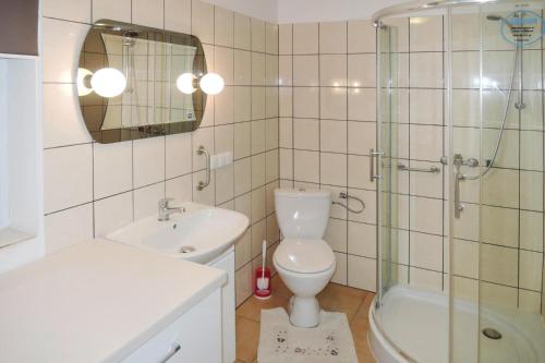 ein Bad mit einem WC, einem Waschbecken und einer Dusche in der Unterkunft Holiday flat, Stepnica in Stepnica