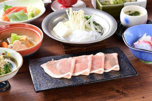 a table topped with plates of food and bowls of food at Mimatsukan in Shibukawa