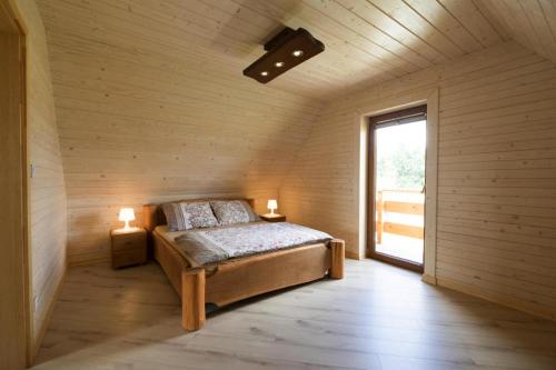1 dormitorio con 1 cama en una habitación con ventana en Holiday resort, Wicie, en Wicie