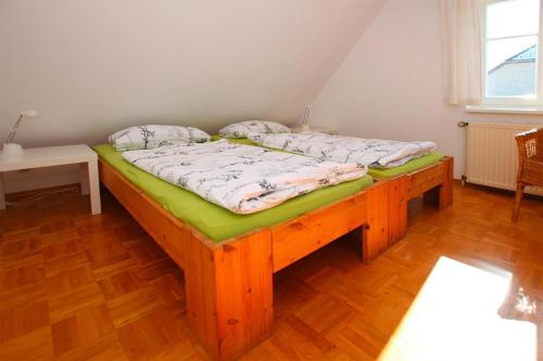 Flat in Klocksin with a garden في Klocksin: سرير في غرفة مع أرضية خشبية