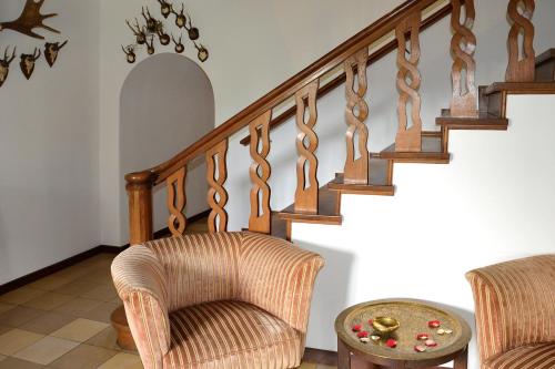 a living room with stairs with chairs and a table at Gut Basthorst in Basthorst