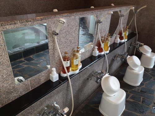 La salle de bains est pourvue d'une douche et de nombreuses bouteilles. dans l'établissement Hakuba Hotel Paipu no Kemuri, à Hakuba