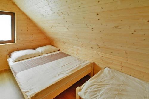 a small room with two beds in a log cabin at Holiday resort, Sarbinowo in Sarbinowo