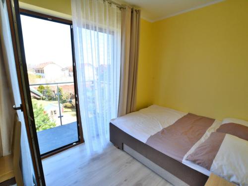 ein Schlafzimmer mit einem Bett und einem großen Fenster in der Unterkunft Holiday resort, Sarbinowo in Sarbinowo