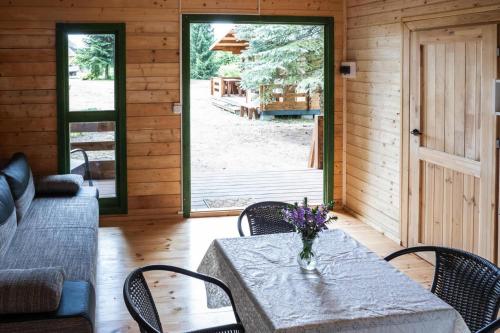 a dining room with a table with a vase of flowers on it at Holiday Home near Baltic Sea and Lake Wise ka in Kodrąb