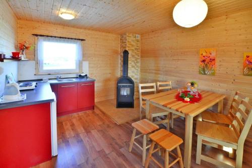 a kitchen and dining room with a table and a stove at Comfortable bungalows with a fireplace and terrace Jaroslawiec in Jarosławiec