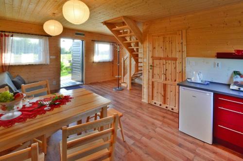 a kitchen and dining room of a log cabin at Comfortable bungalows with a fireplace and terrace Jaroslawiec in Jarosławiec