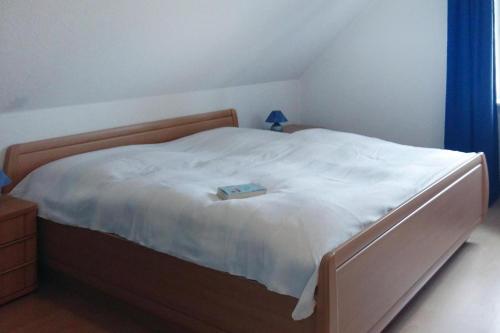 Un dormitorio con una cama con un libro. en Apartments, Toenning, en Tönning