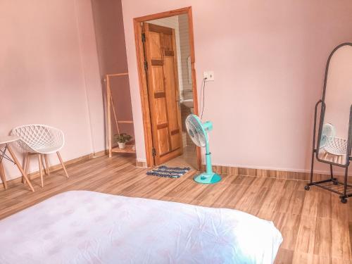 a bedroom with a room with a fan and chairs at Mooka 's Home (Backpackers) in Da Lat