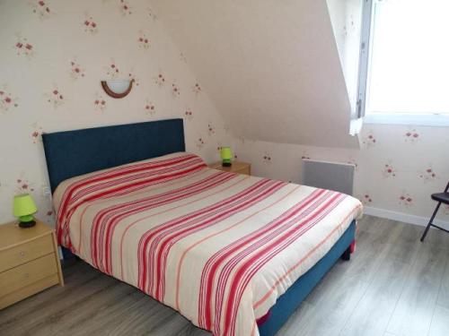 a bedroom with a bed with a striped comforter at Holiday Home in Plouhinec with Sea Views in Plouhinec