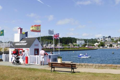 a small building with flags on it next to a body of water at Holiday Home near Rosa Granite Coast Beaches in Langoat