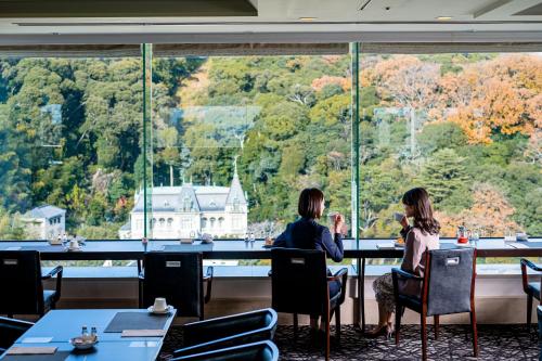 two women sitting at a table looking out of a window at ANA Crowne Plaza Matsuyama by IHG in Matsuyama