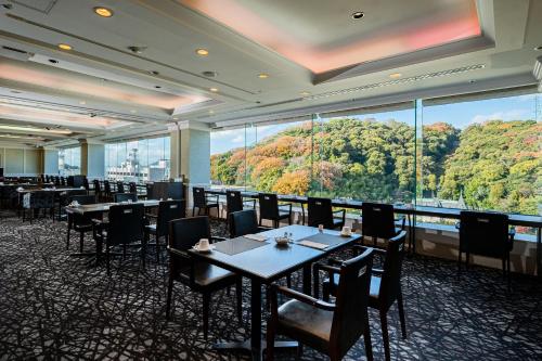 a restaurant with tables and chairs and a large window at ANA Crowne Plaza Matsuyama, an IHG Hotel in Matsuyama