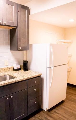 a kitchen with a white refrigerator and a sink at Econo Lodge Vidalia in Vidalia
