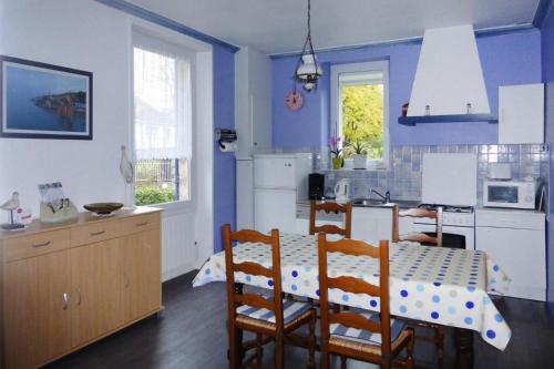 une cuisine avec une table et une cuisine aux murs bleus dans l'établissement Holiday home, Pléneuf-Val-André, à Pléneuf-Val-André