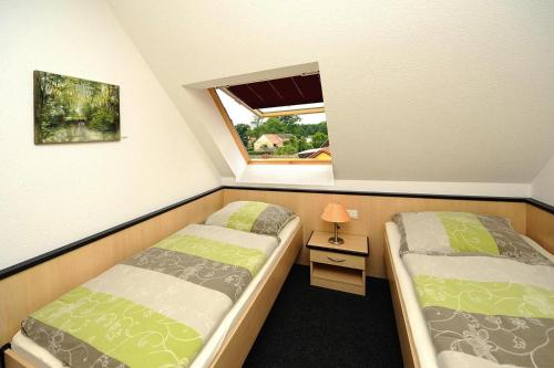 two beds in a small room with a window at Appartements Am Spreewaldfliess, Schlepzig in Schlepzig