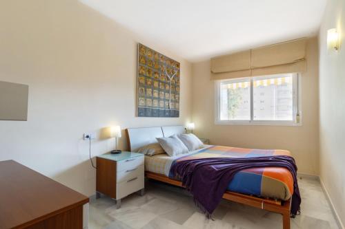 1 dormitorio con cama, escritorio y ventana en Benalmadena with seasonal pool & parking near the beach, en Arroyo de la Miel