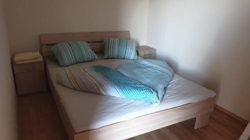 a bed with two pillows on top of it at Galerius Golden Beach Apartment in Siófok