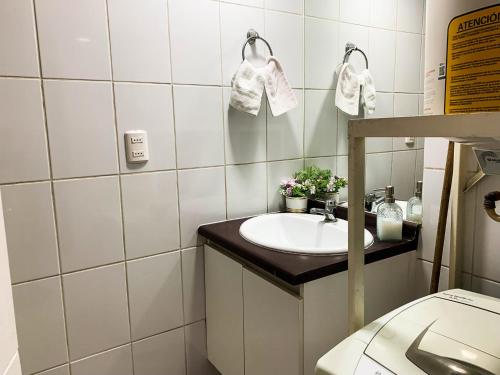 een witte badkamer met een wastafel en een spiegel bij Depto 2 Metro Cal y Canto (Estudio) in Santiago