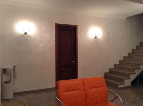 an orange chair in a room with stairs at Lasha Guest House in Makhinjauri