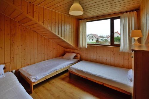 a room with two beds in a wooden cabin at Terraced Houses, Sianozety in Sianozety