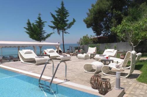 a group of chairs and tables next to a swimming pool at Apartment in Elia Beach for 2 Person in Kalogria