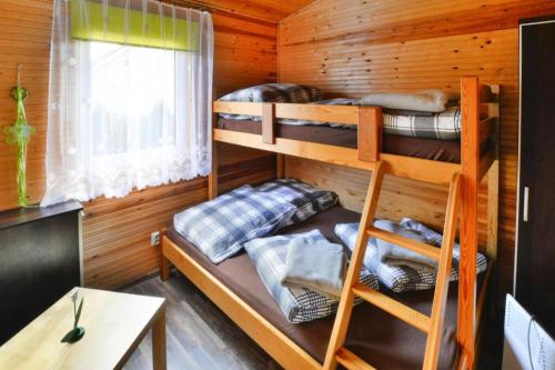 um quarto com beliches num chalé de madeira em Holiday home in Ustronie Morskie not far from the sea em Ustronie Morskie
