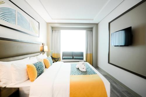 Un dormitorio con una cama con un osito de peluche. en Belmont Hotel Boracay en Boracay