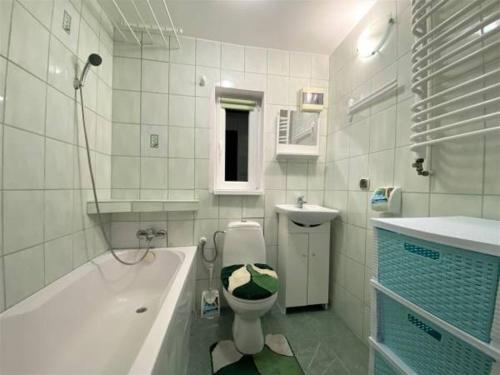 a bathroom with a toilet and a tub and a sink at Domek na Prerii in Ustrzyki Dolne