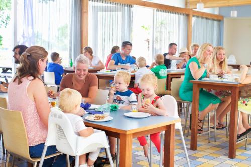 a group of people sitting at tables in a restaurant at Stayokay Hostel Egmond in Egmond-Binnen