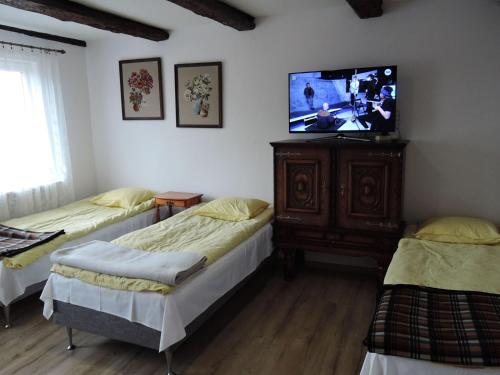 a room with two beds and a flat screen tv at Holiday home in Stepnica in Stepnica