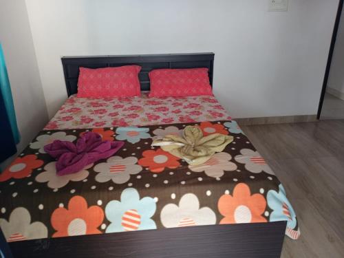 a bedroom with a bed with a floral bedspread at Ocean Shores Hospitality in Candolim