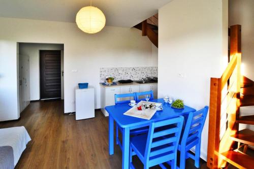 a kitchen with a blue table and chairs in a room at Holiday bungalow for 4 people Jaroslawiec in Jarosławiec