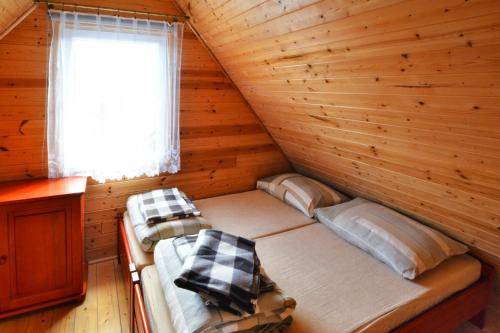 a room with two beds in a log cabin at Holiday home in Ustronie Morskie with a playground in Ustronie Morskie