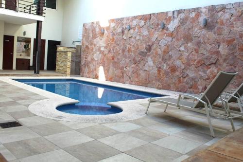 マサトランにあるDepartamento a 200 Mts de la playa y alberca en planta bajaのスイミングプール(椅子付)