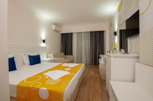 een hotelkamer met een bed met een gele deken bij Fun&Sun Smart Hane sun in Side