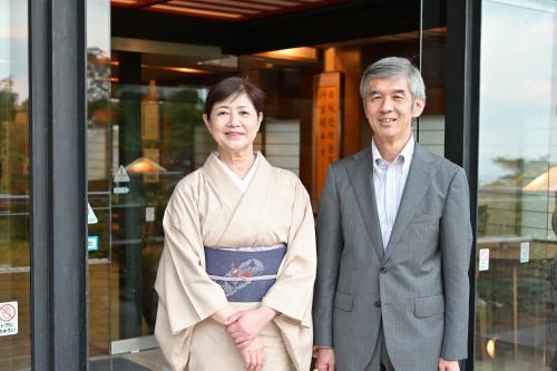 a man and a woman standing in front of a building at Mimatsukan in Shibukawa