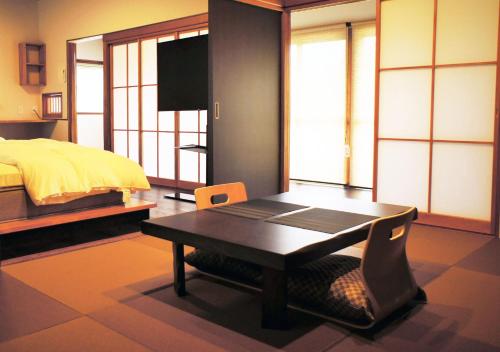 a bedroom with a bed and a desk with a chair at ATAMI SPRING TERRACE HOTEL in Atami