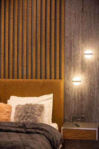 a bedroom with a bed with a wooden headboard at Adryades luxury apartments in Metsovo