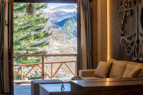 a living room with a couch and a large window at Adryades luxury apartments in Metsovo