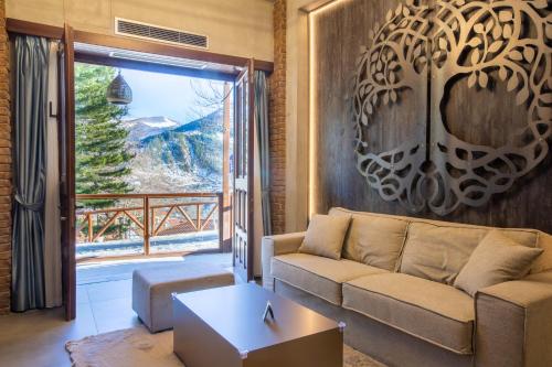 a living room with a couch and a large window at Adryades luxury apartments in Metsovo