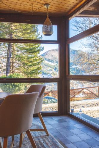 a room with two chairs in front of a window at Adryades luxury apartments in Metsovo