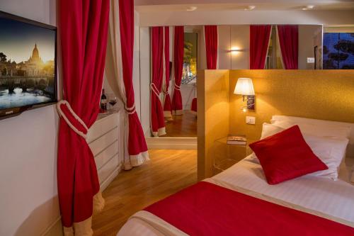 ローマにあるスイート バチカンの赤いカーテン付きのベッドが備わるホテルルームです。